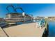 Dock featuring a boat lift and chairs overlooking the water at 5133 Glenn Dr, New Port Richey, FL 34652
