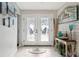 Bright entryway with white double doors, charming coastal decor, and a glimpse of the inviting interior at 5133 Glenn Dr, New Port Richey, FL 34652