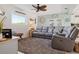 Comfortable living room with a plush gray sofa, a coastal ceiling fan, and lots of light at 5133 Glenn Dr, New Port Richey, FL 34652