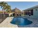 Inviting backyard pool with tiki umbrella, surrounded by brick pavers and palm trees perfect for entertaining at 5133 Glenn Dr, New Port Richey, FL 34652