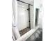 Elegant shower with white tiles, pebble floor, and black fixtures offering a luxurious bathing space at 5133 Glenn Dr, New Port Richey, FL 34652