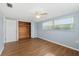 Bright bedroom boasts a ceiling fan, closet, and hardwood floors at 5720 Mockingbird Dr, New Port Richey, FL 34652