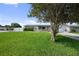 Well-maintained front yard with lush grass and mature trees, providing shade and curb appeal at 5720 Mockingbird Dr, New Port Richey, FL 34652