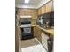 Functional kitchen featuring essential appliances and wood-look cabinetry at 6446 71St N St, Pinellas Park, FL 33781