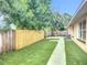 A fenced backyard featuring green turf, a concrete path, and shade trees for outdoor living and relaxation at 6511 3Rd Ne Ave, Bradenton, FL 34208