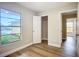 Bedroom with hardwood floors, a large window overlooking greenery, and a bright, inviting atmosphere at 6511 3Rd Ne Ave, Bradenton, FL 34208