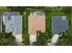 Aerial view of three homes, the middle of which has a pool with a screened enclosure and green lawns at 8731 Tantallon Cir, Tampa, FL 33647