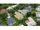 An aerial view of a house in the neighborhood surrounded by lush greenery, trees, and neighboring properties at 8731 Tantallon Cir, Tampa, FL 33647
