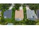 Aerial view of three backyards, one with a screened-in pool, surrounded by green lawns and mature trees at 8731 Tantallon Cir, Tampa, FL 33647
