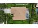 Aerial view of a backyard with a screened pool, green grass, garden space, and trees at 8731 Tantallon Cir, Tampa, FL 33647