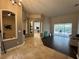 A well-lit entryway featuring tiled and hardwood floors with pillars, leading to the living areas and a pool view at 8731 Tantallon Cir, Tampa, FL 33647
