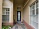 Inviting front entryway featuring tiled floor, brick accents, and a navy blue front door at 8731 Tantallon Cir, Tampa, FL 33647
