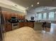 Open kitchen with stainless appliances, wood cabinetry, granite countertops, and breakfast bar at 8731 Tantallon Cir, Tampa, FL 33647