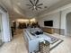 Open concept living room with large sectional sofa, ceiling fan, and access to kitchen at 8731 Tantallon Cir, Tampa, FL 33647