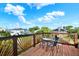 Relax on the cozy deck, featuring charming wood railings and furniture perfect for enjoying the outdoors and beautiful views at 101 Carlyle Dr, Palm Harbor, FL 34683