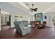 Comfortable living room with plush seating, fireplace, ceiling fan, and large windows for natural light at 101 Carlyle Dr, Palm Harbor, FL 34683