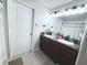 A clean bathroom features a double sink vanity with granite countertops and neutral-colored tile flooring at 10221 Carloway Hills Dr, Wimauma, FL 33598