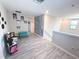 A spacious bonus room with gray vinyl flooring features light gray walls and a splash of gray patterned wallpaper at 10221 Carloway Hills Dr, Wimauma, FL 33598