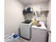 A modern laundry room offers a washer and dryer and plenty of storage with overhead shelving at 10221 Carloway Hills Dr, Wimauma, FL 33598