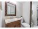 Bathroom features a wood framed mirror, vanity, toilet, and neutral wall paint at 10520 Winrock Pl, Tampa, FL 33624