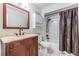 Cozy bathroom with wooden vanity, mirror, and a shower with a brown curtain at 10520 Winrock Pl, Tampa, FL 33624