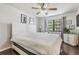 Bright bedroom featuring a large bed, wooden floors, a ceiling fan, and natural light at 10520 Winrock Pl, Tampa, FL 33624