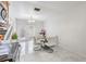 Sunlit dining area featuring a modern glass table, staircase, and sleek tile flooring at 10520 Winrock Pl, Tampa, FL 33624
