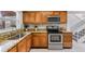 Well-lit kitchen featuring wood cabinets, stainless steel appliances, and granite countertops at 10520 Winrock Pl, Tampa, FL 33624