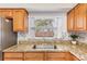 Close up of kitchen featuring granite countertops, tile backsplash, and stainless steel sink at 10520 Winrock Pl, Tampa, FL 33624