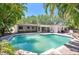 Backyard view featuring swimming pool, screened porch and lush landscaping at 1100 Snell Isle Ne Blvd, St Petersburg, FL 33704