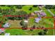 Property aerial view with mature trees, lush yard, several outbuildings, a house, and bordering treeline at 1105 Branch Acres Dr, Plant City, FL 33565