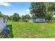 Large grassy backyard with a shed, trailer, and a metal carport at 1105 Branch Acres Dr, Plant City, FL 33565