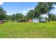 Beautiful, green backyard with a utility trailer, metal carport and storage sheds at 1105 Branch Acres Dr, Plant City, FL 33565