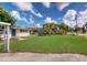 Spacious backyard featuring a large green lawn and mature trees, perfect for outdoor activities at 12113 Victory Dr, Hudson, FL 34667