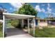 Exterior view of the home featuring a covered parking area and a lawn at 12113 Victory Dr, Hudson, FL 34667