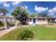 Charming single-story home featuring a front yard with a tree and a bright blue front door at 12113 Victory Dr, Hudson, FL 34667