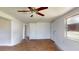 Open living room with wood-look floors, ceiling fan, and a large window at 12113 Victory Dr, Hudson, FL 34667