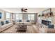 Staged living room boasts hardwood floors, large windows, stone fireplace, and sofas at 12113 Victory Dr, Hudson, FL 34667