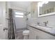 Modern bathroom with subway tile, granite vanity, and shower with gray curtain at 124 E Virginia Ln, Clearwater, FL 33759