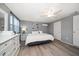 Cozy bedroom features hardwood floors, ceiling fan, mini-split air conditioner, and neutral gray walls at 124 E Virginia Ln, Clearwater, FL 33759