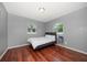 Comfortable bedroom with wood flooring, natural light, and neutral color scheme at 124 E Virginia Ln, Clearwater, FL 33759