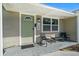 Inviting front porch with a green door, black seating, and stylish address numbers at 124 E Virginia Ln, Clearwater, FL 33759
