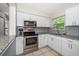Well-lit kitchen with granite counters, subway tile backsplash, and stainless steel appliances at 124 E Virginia Ln, Clearwater, FL 33759
