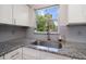 Granite countertop with stainless steel sink in kitchen, bright view to outside at 124 E Virginia Ln, Clearwater, FL 33759
