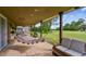 A covered back patio with a hammock, outdoor furniture, and views of the large grassy yard at 12915 Carlington Ln, Riverview, FL 33579