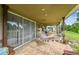 Relaxing covered patio with hammock, dining area, and view of the green backyard and mature trees at 12915 Carlington Ln, Riverview, FL 33579