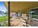 Expansive covered patio with brick flooring, hammock, stone fireplace, and outdoor dining set at 12915 Carlington Ln, Riverview, FL 33579