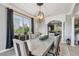 Dining room with chandelier lighting, large windows with black curtains, and access to the kitchen at 12915 Carlington Ln, Riverview, FL 33579