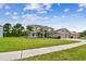 Home exterior with a well-manicured lawn, mature trees and a two-car garage at 12915 Carlington Ln, Riverview, FL 33579