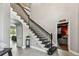 Spacious foyer boasting staircase with dark wood banister and a doorway to the theater room at 12915 Carlington Ln, Riverview, FL 33579